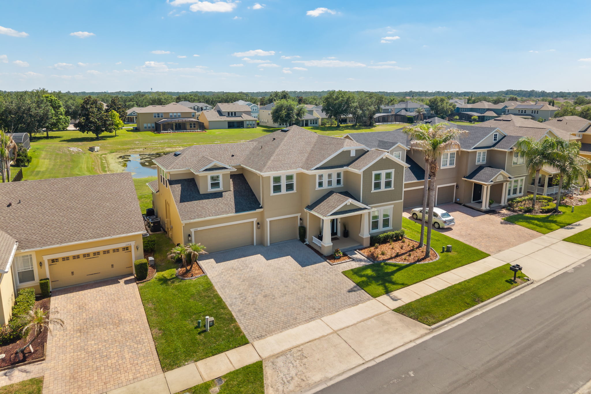 Aerial view of 11716 Sheltering Pine Drive showing the screened pool and pond